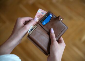 person holding brown leather card wallet