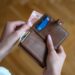 person holding brown leather card wallet